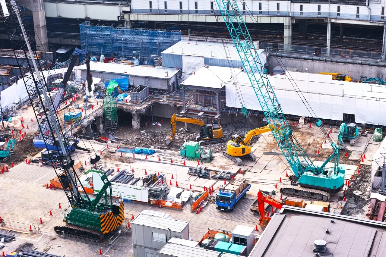 Active construction site with cranes and heavy machinery